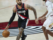 Portland Trail Blazers guard Gary Trent Jr., left, works around Cleveland Cavaliers guard Darius Garland during the second half of an NBA basketball game in Portland, Ore., Friday, Feb. 12, 2021.