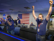 In this photo provided by NASA, members of NASA's Perseverance rover team react in mission control after receiving confirmation the spacecraft successfully touched down on Mars, Thursday, Feb. 18, 2021, at NASA's Jet Propulsion Laboratory in Pasadena, Calif. The landing of the six-wheeled vehicle marks the third visit to Mars in just over a week. Two spacecraft from the United Arab Emirates and China swung into orbit around the planet on successive days last week.