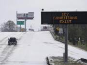 A truck drives past a highway sign Monday, Feb. 15, 2021, in Houston. A frigid blast of winter weather across the U.S. plunged Texas into an unusually icy emergency Monday that knocked out power to more than 2 million people and shut down grocery stores and dangerously snowy roads. (AP Photo/David J.