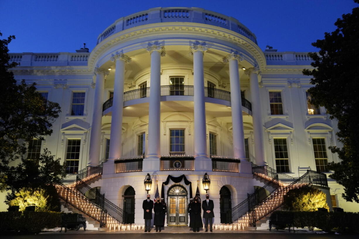 From left, President Joe Biden, first lady Jill Biden, Vice President Kamala Harris and her husband, Doug Emhoff, stand outside the White House during a ceremony Monday to honor the 500,000 Americans who died from COVID-19.