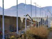 Crews work on the construction of a section of border wall Dec. 8 in the San Bernardino National Wildlife Refuge in Douglas, Ariz.