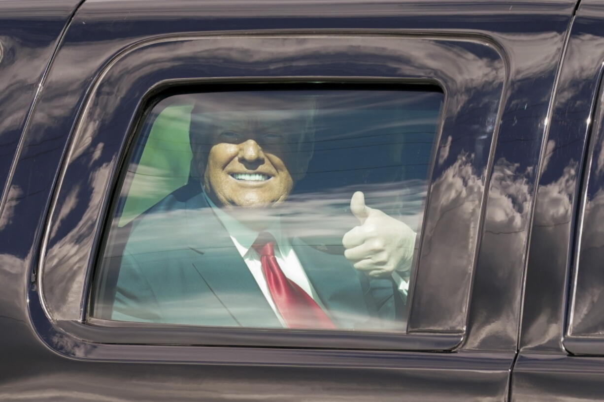 President Donald Trump gestures to supporters en route to his Mar-a-Lago Florida Resort on Wednesday, Jan. 20, 2021, in West Palm Beach, Fla.