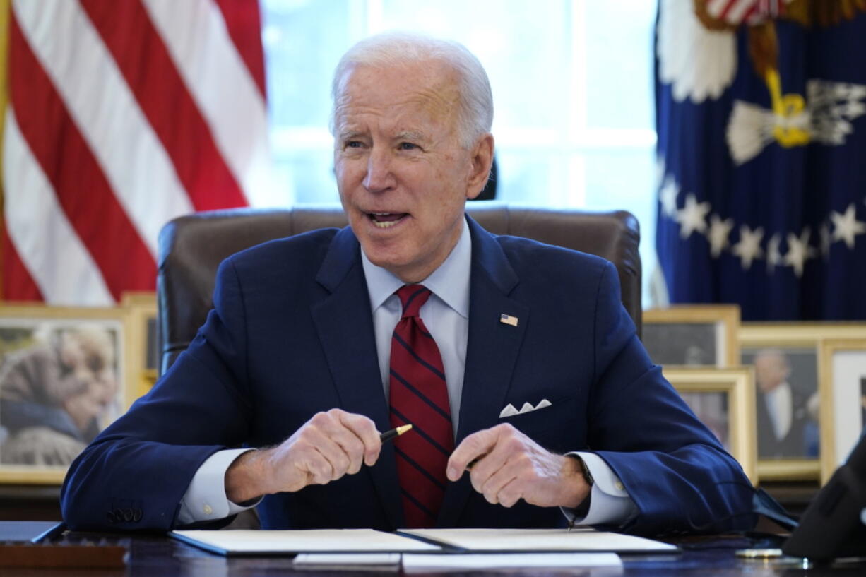 FILE - In this Jan. 28, 2021 file photo, President Joe Biden signs a series of executive orders in the Oval Office of the White House in Washington. Biden campaigned on raising the national minimum wage to $15 per hour and attached a proposal doing just that to the $1.9 trillion coronavirus pandemic relief bill.