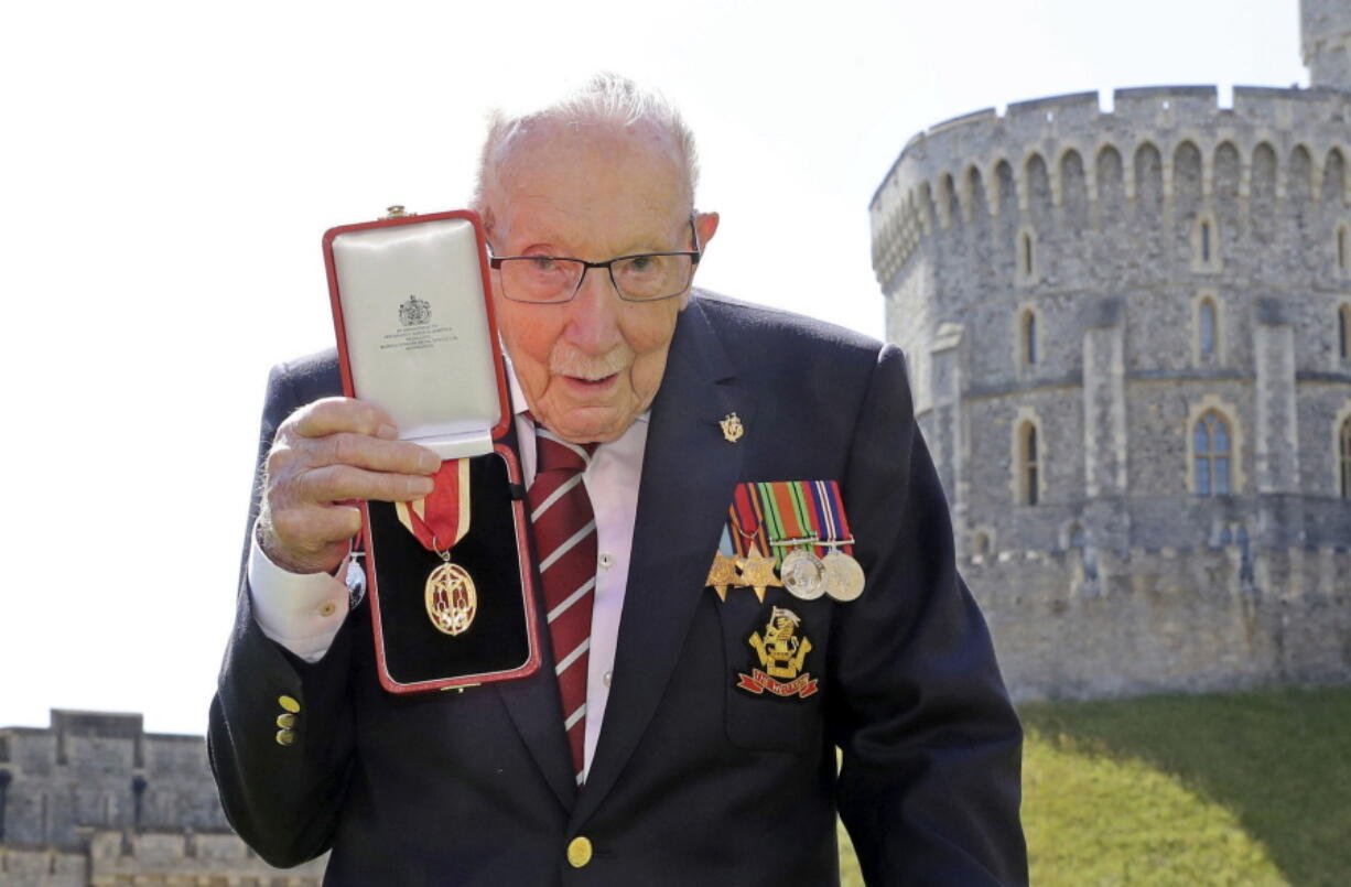 FILE - In this Friday, July 17, 2020 file photo, Captain Sir Thomas Moore poses for the media after receiving his knighthood from Britain&#039;s Queen Elizabeth, during a ceremony at Windsor Castle in Windsor, England. Tom Moore, the 100-year-old World War II veteran who captivated the British public in the early days of the coronavirus pandemic with his fundraising efforts, has died, Tuesday Feb. 2, 2021.