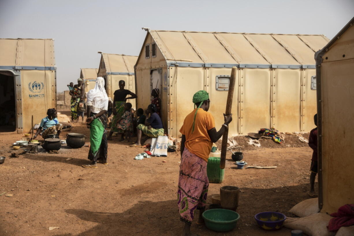 Displaced women prepare food Monday Feb. 8, 2021 in the Kaya camp, 100 kms North of Ouagadougou, Burkina Faso.  A report by humanitarian groups says sexual assault cases in one region increased five-fold during a three-month period in 2020. Aid groups say jihadists are not the only perpetrators and that there has been a sharp increase in domestic violence and exploitation of displaced women by host communities.