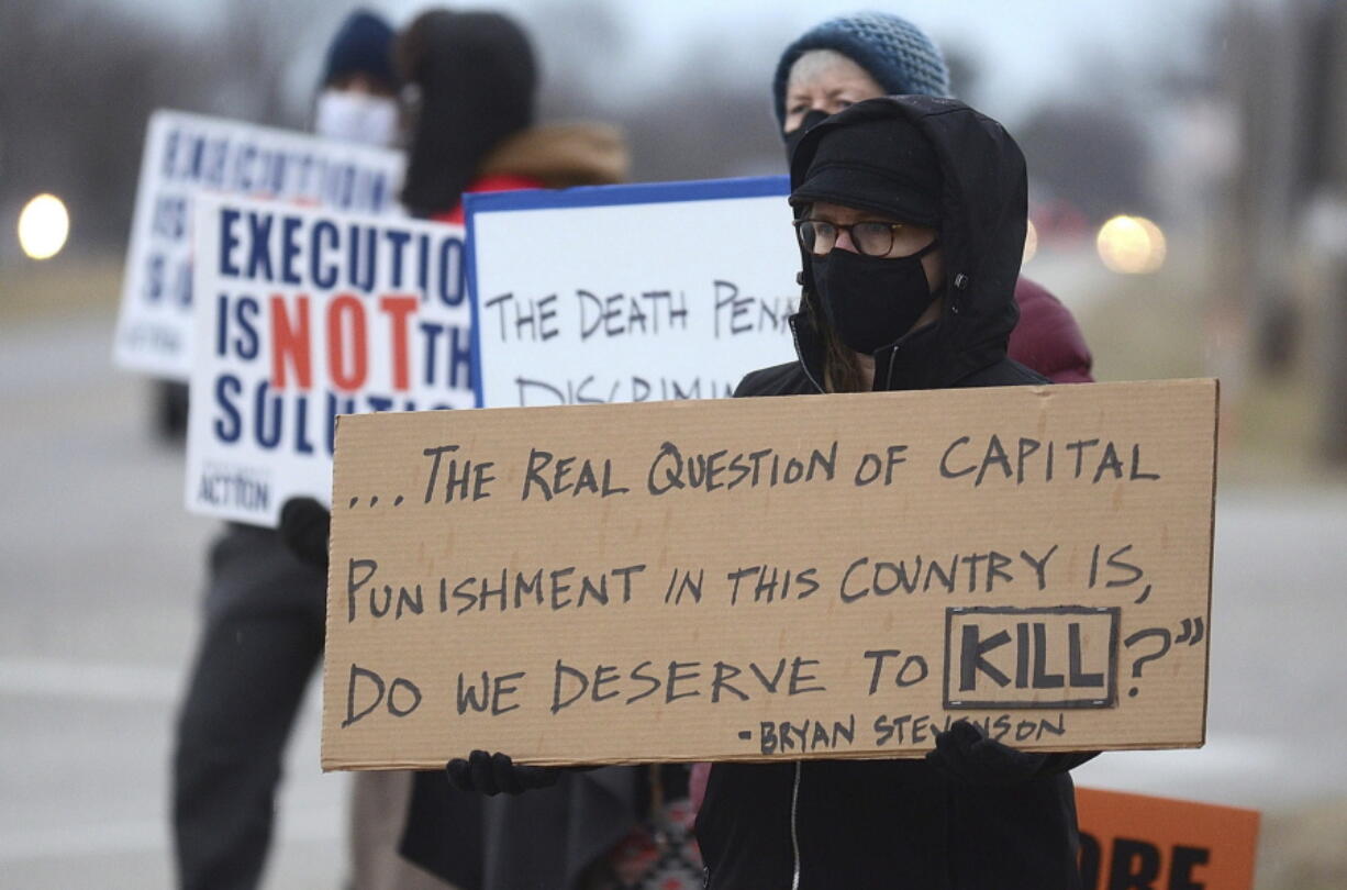 Christina Bollo of Urbana, Illinois, holds a sign Jan. 14 as she protests the execution of Corey Johnson, near the Federal Correctional Complex, in Terre Haute, Ind. (Joseph C.