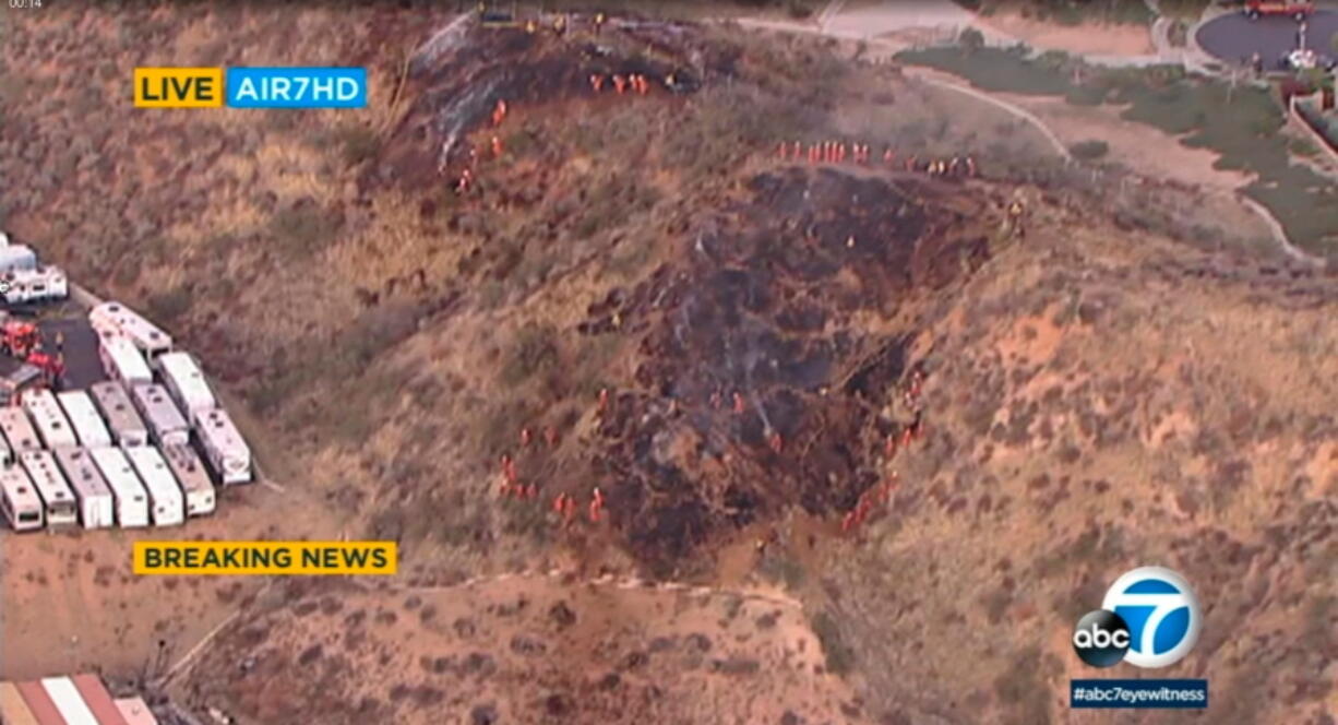 This photo from KABC-TV video shows firefighters putting out a grass fire in Santa Clarita, Calif., Tuesday, Feb. 2, 2021. Three people on a film set were critically hurt in an explosion that sparked a grass fire near Los Angeles on Tuesday, authorities said. The blast was reported in a mixed use industrial neighborhood of Santa Clarita, said Los Angeles County Sheriff&#039;s Deputy Abraham Bedoyan.