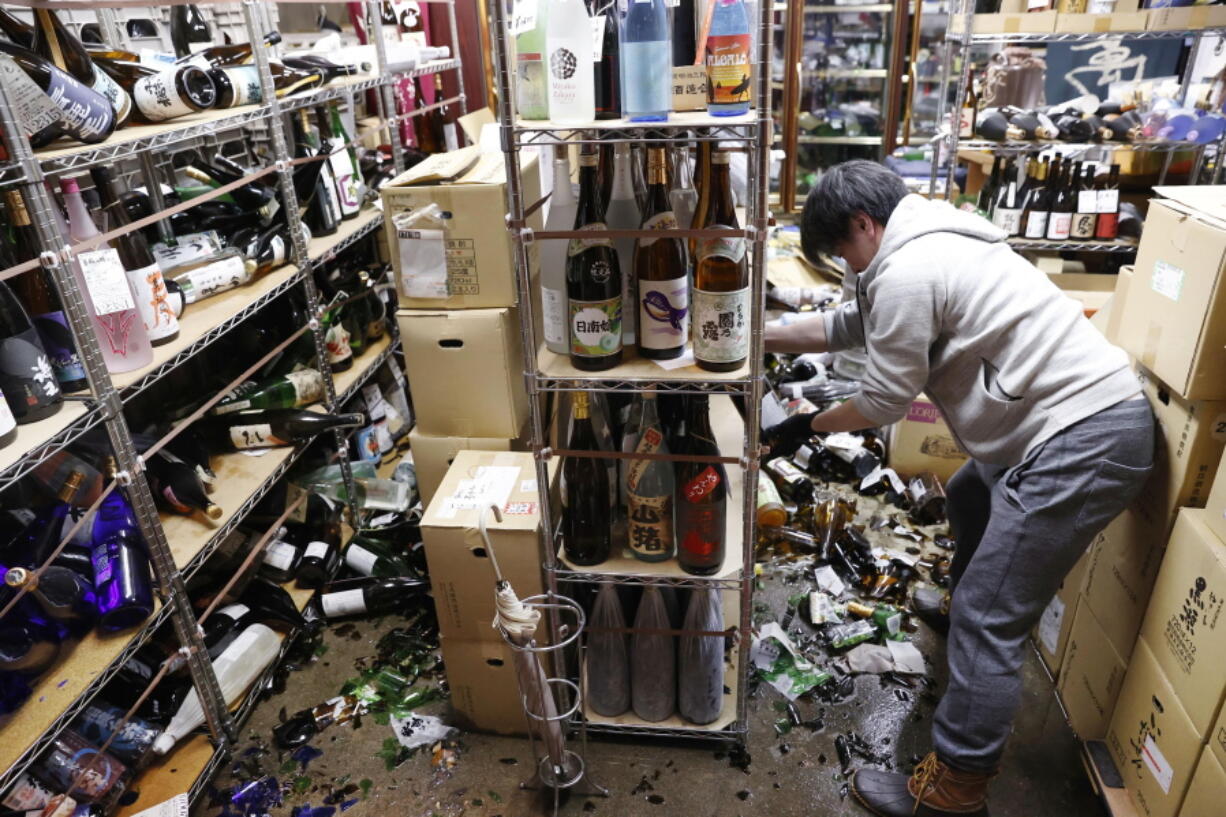 A liquor shop&#039;s manager clears the damaged bottles following an earthquake in Fukushima, northeastern Japan Saturday, Feb. 13, 2021. The Japan Meteorological Agency says a strong earthquake has hit off the coast of northeastern Japan, shaking Fukushima, Miyagi and other areas.