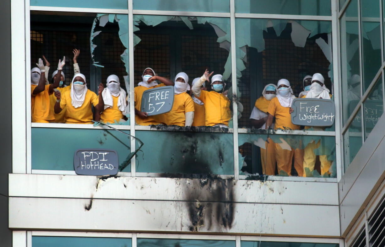 Inmates yell from broken windows at the St. Louis Justice Center, known as the city jail, on Saturday in St. Louis, Mo. (Robert Cohen/St.