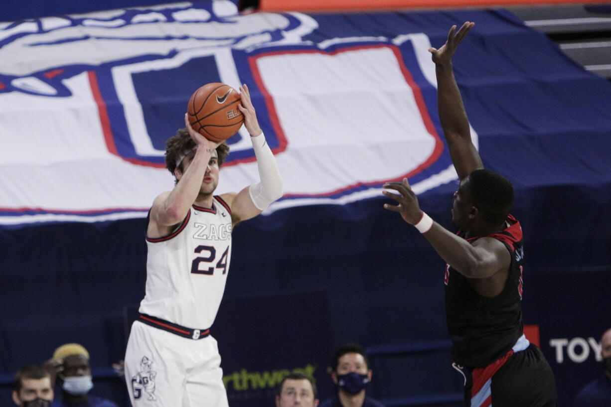 Gonzaga forward Corey Kispert shoots as Loyola Marymount guard Eli Scott defends during the second half of an NCAA college basketball game in Spokane, Wash., Saturday, Feb. 27, 2021.