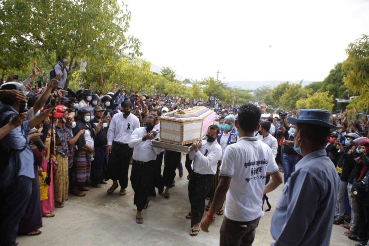 The casket containing the body of Mya Thwet Thwet Khine being carried through the crowds towards the cemetery in Naypyitaw Myanmar, Sunday, Feb. 21, 2021. Mya Thwet Thwet Khine was the first confirmed death among the many thousands who have taken to the streets to protest the Feb. 1 coup that toppled the elected government of Aung San Suu Kyi. The woman was shot on Feb. 9, two days before her 20th birthday, at a protest in the capital Nayptitaw, and died Friday.