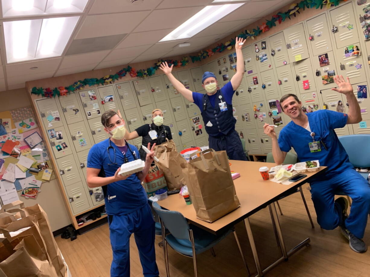 This photo provided by Brittney Caldera shows, from left to right, Oregon Health &amp; Science University nurses Nick Greenwood, Callie Harling, Derrell Wheeler and Orion Meredith as they eat a meal delivered to the hospital&#039;s frontline COVID-19 health care workers in a break room, Jan. 10, 2021, at Oregon Health &amp; Science University, in Portland, Ore. The program that provided the meals, funded by a grant from an Oregon-based insurance fund, recently expired but the hospital is hoping for new donations to reboot it as COVID-19 variants could cause a new surge of cases.