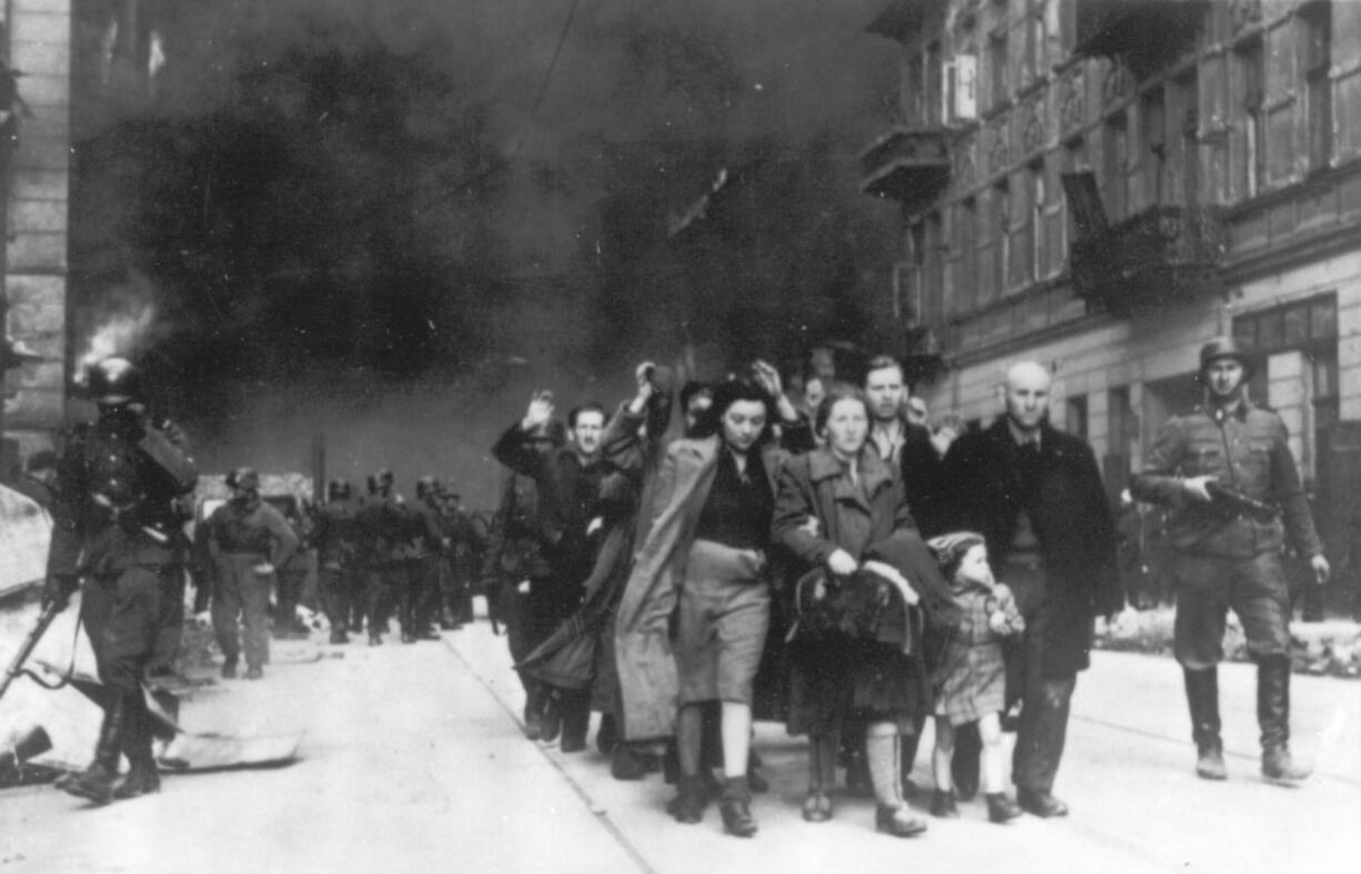 FILE - In this 1943 photo, a group of Polish Jews are led away for deportation by German SS soldiers, during the destruction of the Warsaw Ghetto by German troops after an uprising in the Jewish quarter. Two Polish historians are facing a libel trial for a scholarly examination of Polish behavior during World War II, a case whose outcome is expected to determine the fate of independent Holocaust research under Poland&#039;s nationalist government. A verdict is expected Feb. 9.