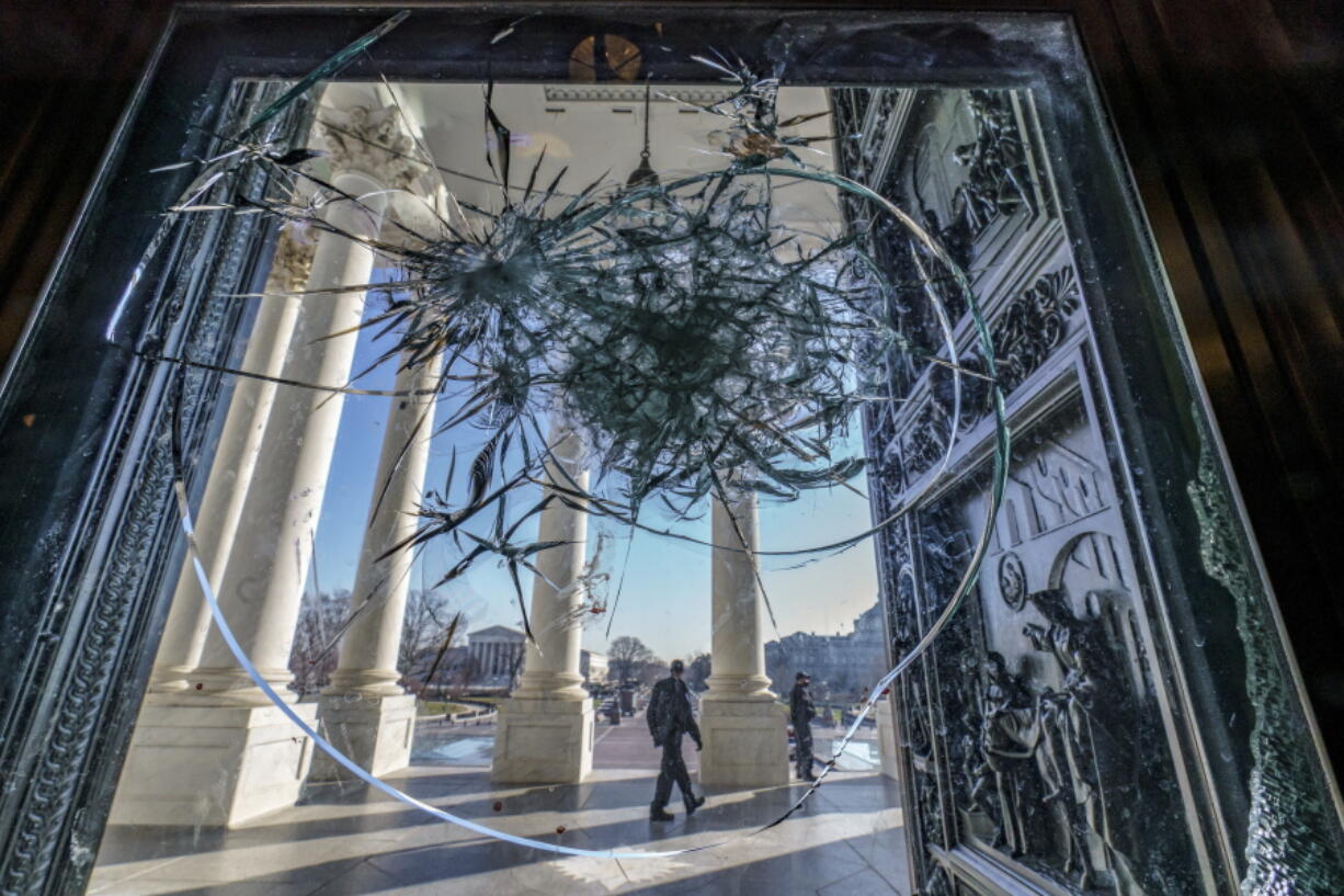 FILE - In this Jan. 12, 2021, file photo, shattered glass from the attack on Congress by a pro-Trump mob is seen in the doors leading to the Capitol Rotunda, in Washington. (AP Photo/J.