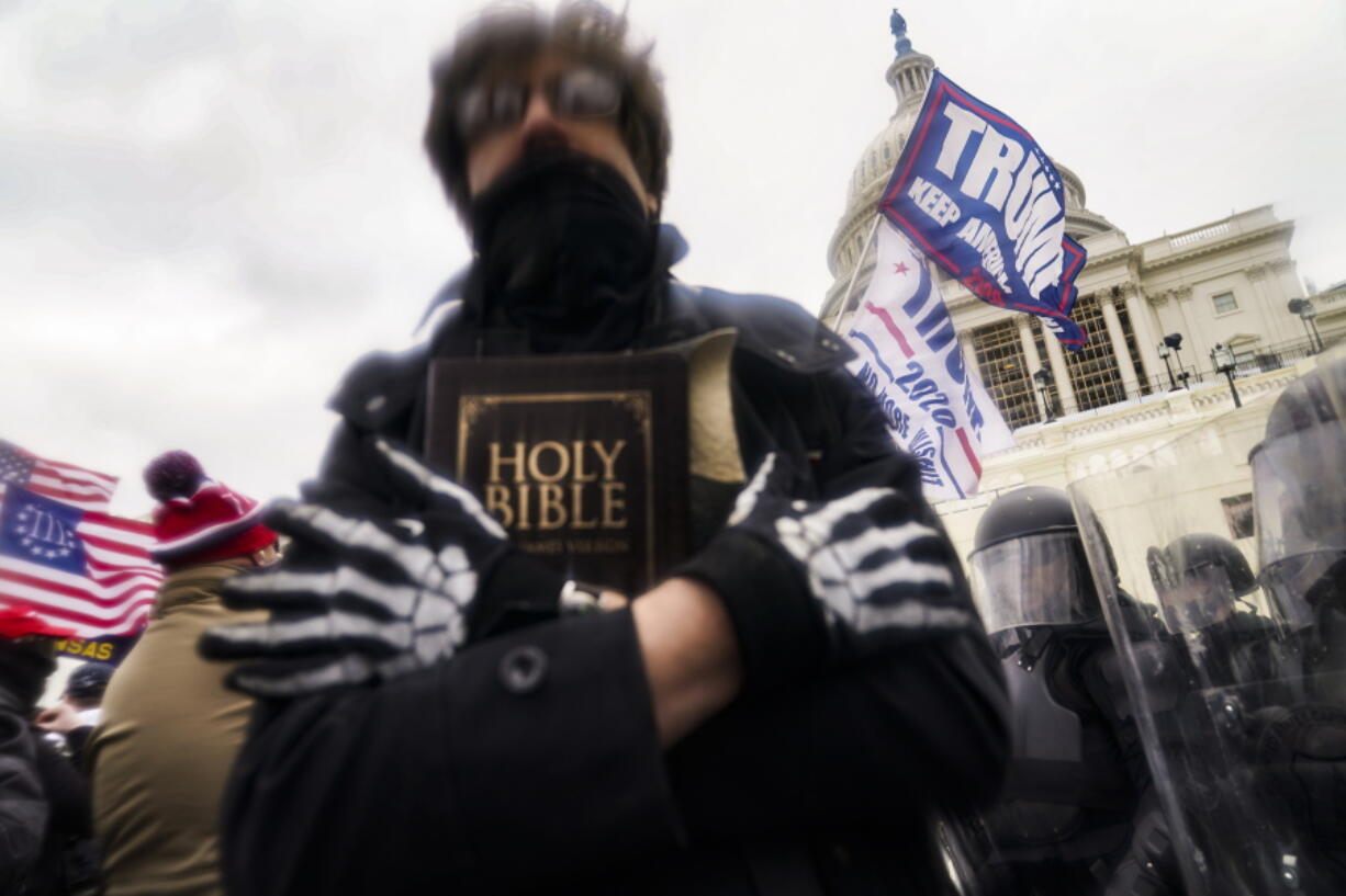 A man holds a Bible as Trump supporters gather outside the Capitol in Washington on Jan. 6.