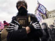 A man holds a Bible as Trump supporters gather outside the Capitol in Washington on Jan. 6.