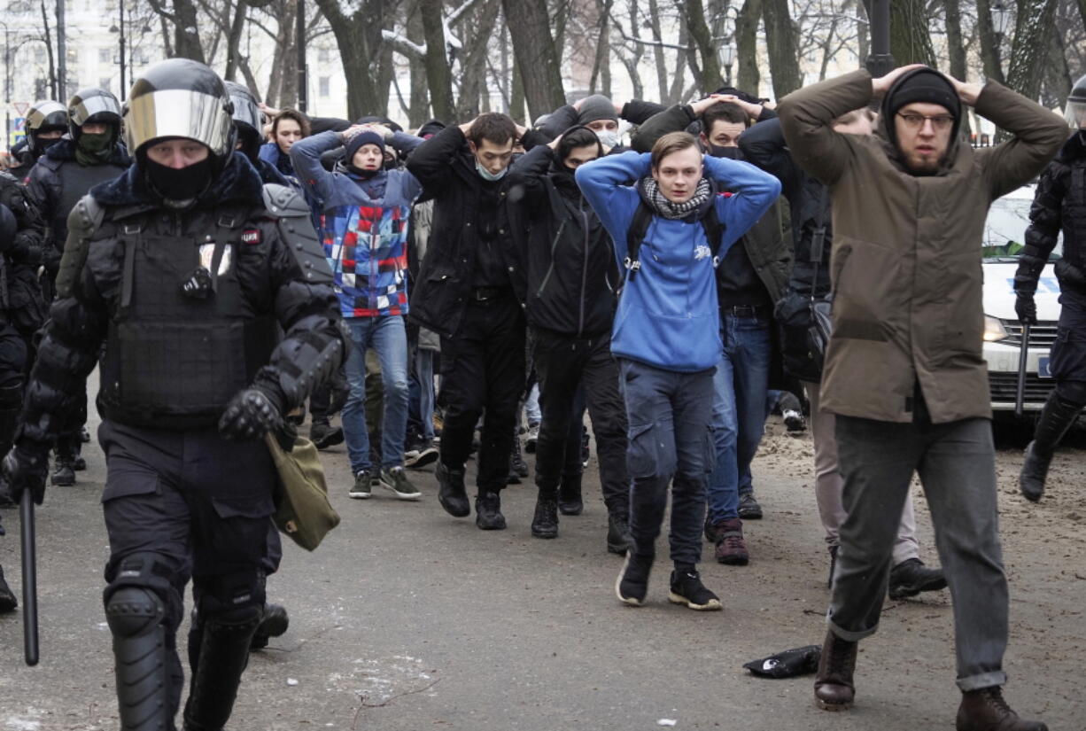 FILE - In this Sunday, Jan. 31, 2021 file photo, detained protesters walk escorted by police during a protest against the jailing of opposition leader Alexei Navalny in St. Petersburg, Russia. A prison sentence for Navalny and a sweeping crackdown on protesters demanding his release reflect the Kremlin&#039;s steely determination to fend off threats to its political monopoly at any cost.