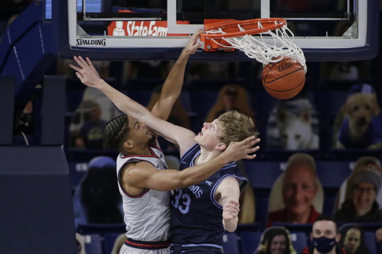 Gonzaga guard Aaron Cook, left, dunks over San Diego forward Ben Pyle during the second half of an NCAA college basketball game in Spokane, Wash., Saturday, Feb. 20, 2021.