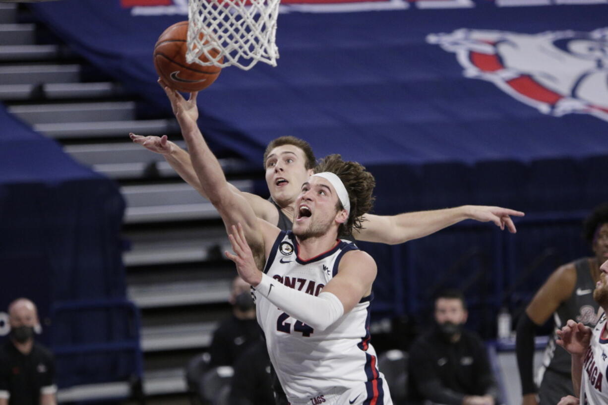 Gonzaga forward Corey Kispert, front, shoots in front of Santa Clara forward Josip Vrankic during the second half of an NCAA college basketball game in Spokane, Wash., Thursday, Feb. 25, 2021.