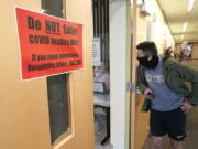 Josef Triman, a senior defensive back at Pacific Lutheran, waits in line to take a three-times-a-week COVID-19 test Monday, Feb. 1, 2021, in Tacoma, Wash. Like the big programs that played in the fall, testing, distancing and protective equipment have topped the priority list in trying to pull off a season. (AP Photo/Ted S.