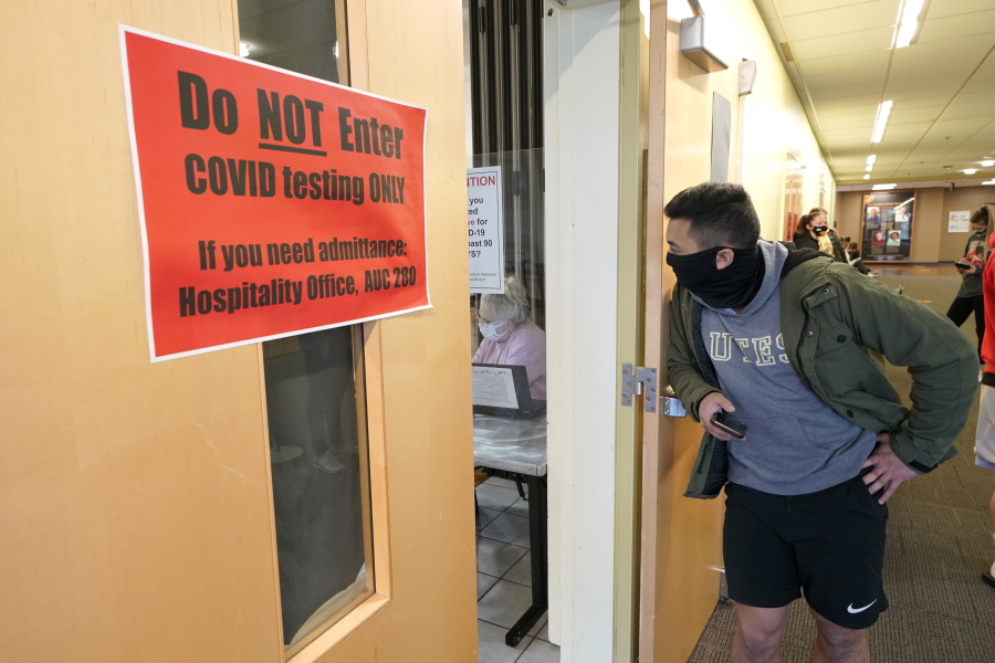 Josef Triman, a senior defensive back at Pacific Lutheran, waits in line to take a three-times-a-week COVID-19 test Monday, Feb. 1, 2021, in Tacoma, Wash. Like the big programs that played in the fall, testing, distancing and protective equipment have topped the priority list in trying to pull off a season. (AP Photo/Ted S.