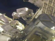 In this image taken from NASA video, NASA astronauts Mike Hopkins, left, and Victor Glover work outside the International Space Station on Monday, Feb. 1, 2021. The pair ventured out on their second spacewalk in under a week Monday to complete a four-year effort to modernize the International Space Station&#039;s power grid.