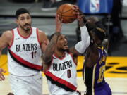 Los Angeles Lakers guard Dennis Schroder (17) blocks a shot by Portland Trail Blazers guard Damian Lillard (0) during the first half of an NBA basketball game Friday, Feb. 26, 2021, in Los Angeles. (AP Photo/Mark J.