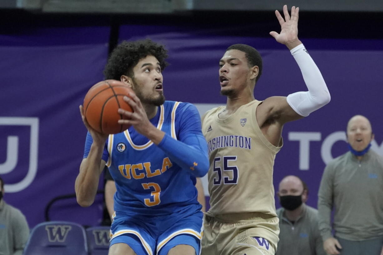 UCLA guard Johnny Juzang, left, looks to shoot around the defense of Washington guard Quade Green (55) during the second half of an NCAA college basketball game, Saturday, Feb. 13, 2021, in Seattle. (AP Photo/Ted S.