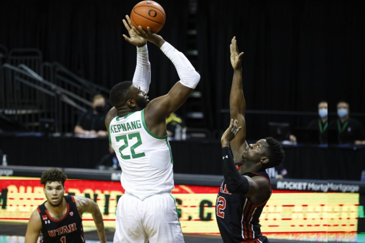 Oregon center Franck Kepnang (22) shoots over Utah center Lahat Thioune (32) during an NCAA college basketball game in Eugene, Ore., Saturday, Feb. 20, 2021.