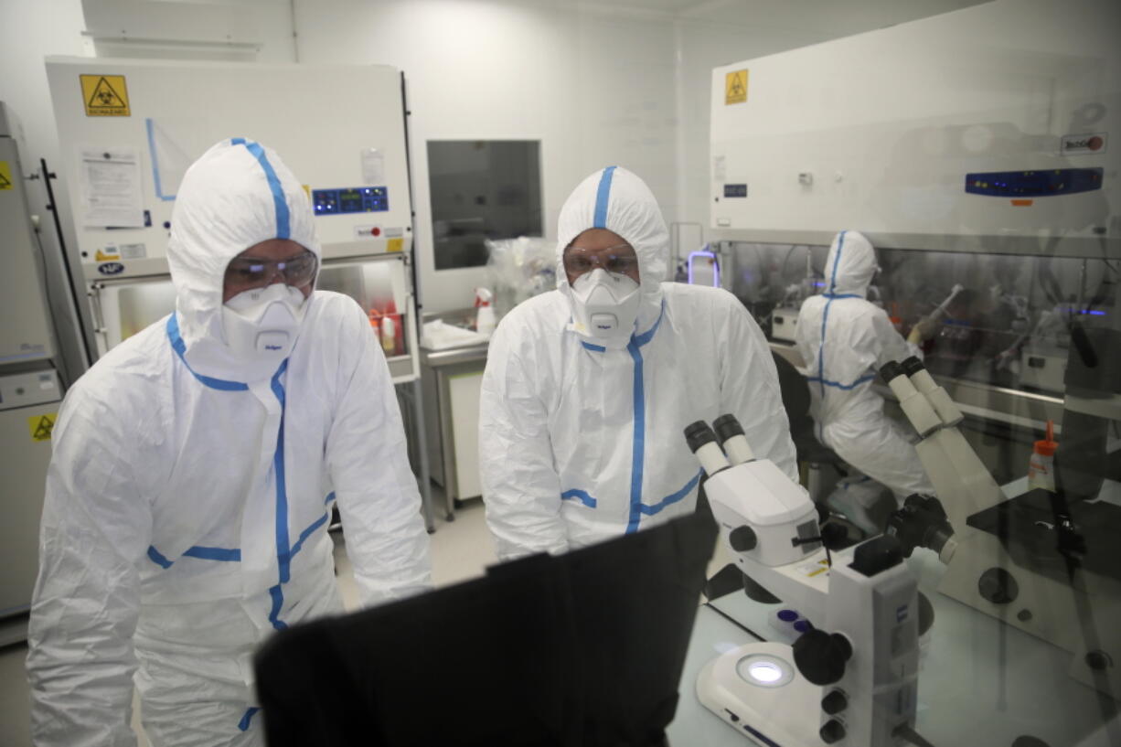 Laboratory technicians work at Valneva headquarters in Saint-Herblain, western France, Wednesday, Feb. 3, 2021. French pharmaceutical startup Valneva had big news in September: a government contract for 60 million doses of its coronavirus vaccine candidate. The buyer? The United Kingdom -- not the European Union, as might be expected for a company on the banks of the Loire.