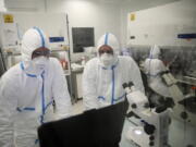 Laboratory technicians work at Valneva headquarters in Saint-Herblain, western France, Wednesday, Feb. 3, 2021. French pharmaceutical startup Valneva had big news in September: a government contract for 60 million doses of its coronavirus vaccine candidate. The buyer? The United Kingdom -- not the European Union, as might be expected for a company on the banks of the Loire.