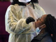 Jazmyn Finney is administered a coronavirus 15-minute rapid test at the student health center on campus at North Carolina Agricultural and Technical State University in Greensboro, N.C., Wednesday, Feb. 3, 2021. As vaccinations slowly ramp up, some experts say turning to millions more rapid tests that are cheaper but technically less accurate may improve the chances of identifying sick people during the critical early days of infection, when they are most contagious.