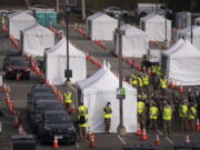 FILE - In this Feb. 16, 2021, file photo, motorists wait to get their COVID-19 vaccine at a federally-run vaccination site set up on the campus of California State University of Los Angeles in Los Angeles. California&#039;s new system of delivering, tracking and scheduling coronavirus vaccines goes live Sunday, Feb. 21, 2021, for 7 million people in a handful of counties as Gov. Gavin Newsom attempts to smooth out what has been a confusing and disjointed rollout hampered by limited national supply. (AP Photo/Jae C.