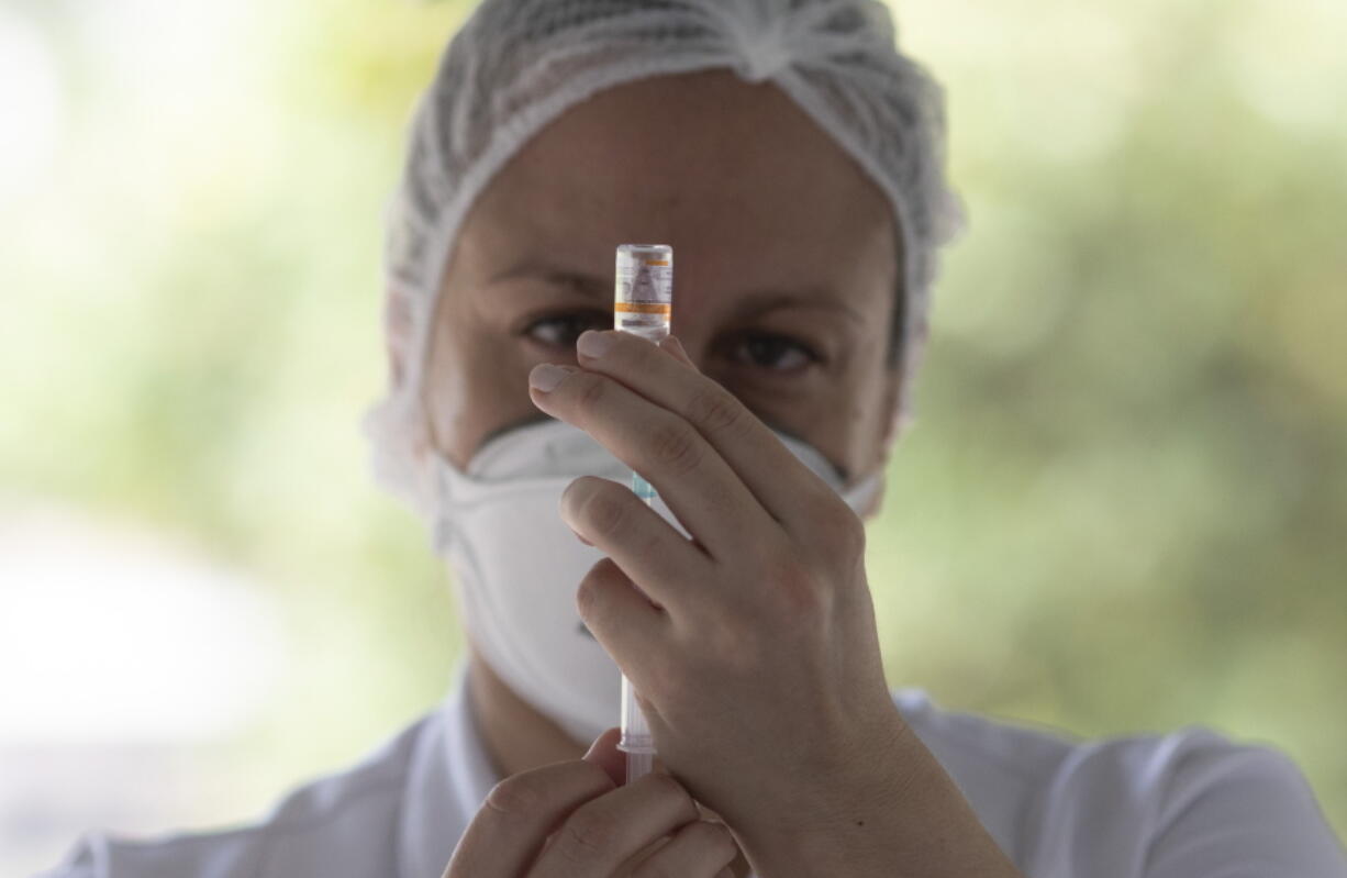 A health worker prepares a dose of China&#039;s Sinovac CoronaVac vaccine Monday during a priority COVID-19 vaccination program for the elderly at a drive-thru vaccination center in Rio de Janeiro, Brazil.