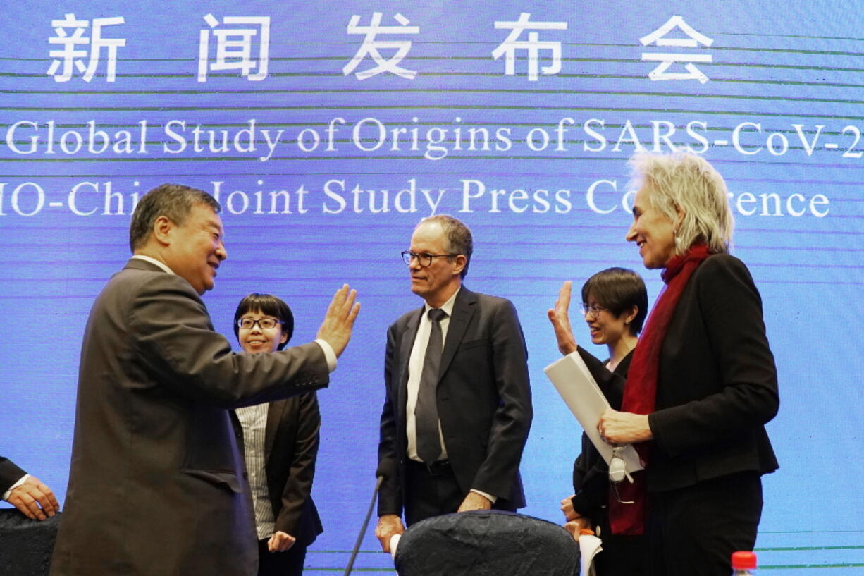 Marion Koopmans, right, and Peter Ben Embarek, center, of the World Health Organization team say farewell to their Chinese counterpart Liang Wannian, left, after a WHO-China Joint Study Press Conference held at the end of the WHO mission in Wuhan, China, Tuesday, Feb. 9, 2021.