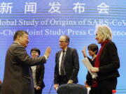 Marion Koopmans, right, and Peter Ben Embarek, center, of the World Health Organization team say farewell to their Chinese counterpart Liang Wannian, left, after a WHO-China Joint Study Press Conference held at the end of the WHO mission in Wuhan, China, Tuesday, Feb. 9, 2021.