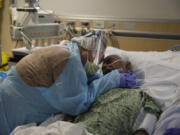 FILE - In this July 31, 2020, file photo, Romelia Navarro, 64, weeps while hugging her husband, Antonio, in his final moments in a COVID-19 unit at St. Jude Medical Center in Fullerton, Calif. The U.S. death toll from COVID-19 has almost topped 500,000 -- a number so staggering that a top health researchers says it is hard to imagine an American who hasn&#039;t lost a relative or doesn&#039;t know someone who died. (AP Photo/Jae C.