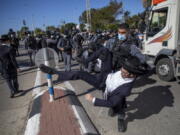 File - In this Sunday, Jan. 24, 2021 file photo, Israeli police officers clash with ultra-Orthodox Jews in Ashdod, Israel,. Ultra-Orthodox demonstrators clashed with Israeli police officers dispatched to close schools in Jerusalem and Ashdod that had opened in violation of coronavirus lockdown rules, on Sunday.