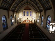 FILE - In this Sunday, April 5, 2020, file photo, The Most Rev. Peter Jugis, Bishop of Charlotte, conducts Palm Sunday services inside the empty St. Patrick Cathedral in Charlotte, N.C. Due to the coronavirus pandemic, the service was closed to the public but was live streamed across western North Carolina. Catholic entities in the Charlotte Diocese received more than $8 million in paycheck program aid. (David T.