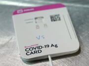 FILE - This Wednesday, Feb. 3, 2021 file photo shows a BinaxNOW rapid COVID-19 test made by Abbott Laboratories, in Tacoma, Wash. After a year of struggling to boost testing, communities across the country are seeing plummeting demand for the service, in some cases shuttering testing sites or even trying to return supplies. (AP Photo/Ted S.