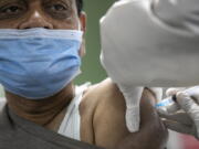 FILE - In this Jan. 27, 2021, file photo, Nepalese doctor receives receives the AstraZeneca/Oxford vaccine, at Teaching Hospital in Kathmandu, Nepal. India has gifted neighbors, including Sri Lanka, Bangladesh and Nepal, with more than 5 million doses.