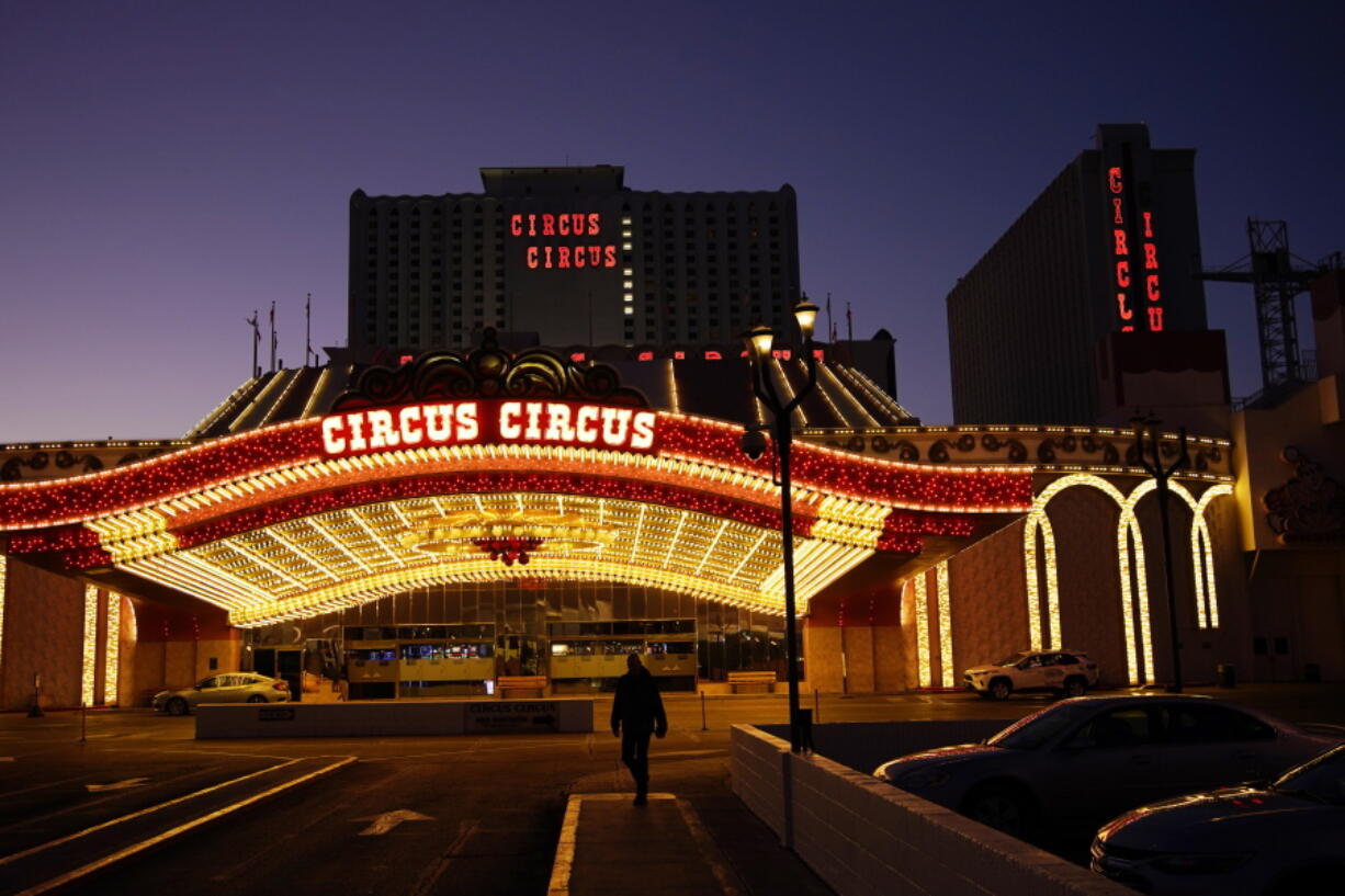 A man walks in front of the Circus Circus hotel and casino in Las Vegas, Feb. 4, 2021. The toll of the coronavirus is reshaping Las Vegas almost a year after the pandemic took hold. The tourist destination known for bright lights, big crowds, indulgent meals and headline shows is a much quieter place these days.