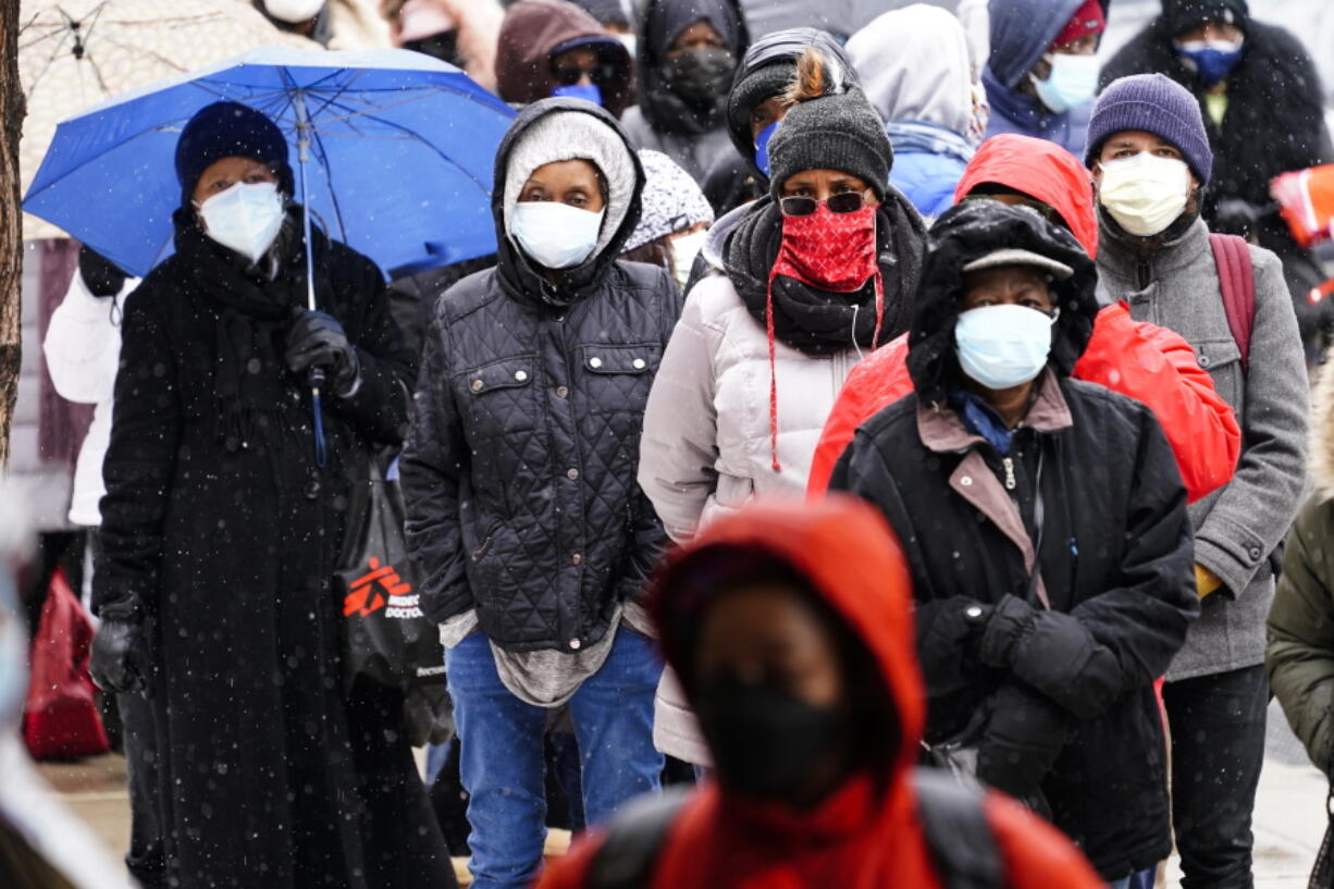 FILE - In this Feb. 19, 2021, file photo, people wait in line at a 24-hour, walk-up COVID-19 vaccination clinic hosted by the Black Doctors COVID-19 Consortium at Temple University&#039;s Liacouras Center in Philadelphia. At least for now, U.S. health authorities say after being vaccinated, people should follow the same rules as everybody else about wearing a mask, keeping a 6-foot distance and avoiding crowds even after they&#039;ve gotten their second vaccine dose.