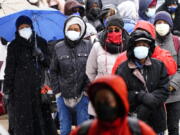 FILE - In this Feb. 19, 2021, file photo, people wait in line at a 24-hour, walk-up COVID-19 vaccination clinic hosted by the Black Doctors COVID-19 Consortium at Temple University&#039;s Liacouras Center in Philadelphia. At least for now, U.S. health authorities say after being vaccinated, people should follow the same rules as everybody else about wearing a mask, keeping a 6-foot distance and avoiding crowds even after they&#039;ve gotten their second vaccine dose.