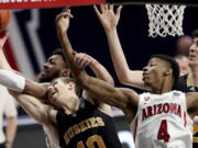 Arizona forward Jordan Brown (21), left, and guard Dalen Terry (4) tangle with Washington guard Erik Stevenson (10) and center Riley Sorn (52) for control of a rebound in the first half of an NCAA college basketball game Saturday, Feb. 27, 2021, in Tucson, Ariz.