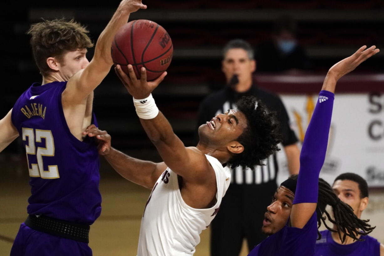 Arizona State guard Remy Martin (1) drives between Washington guard Cole Bajema (22) and forward Hameir Wright during the first half of an NCAA college basketball game, Thursday, Feb. 25, 2021, in Tempe, Ariz.