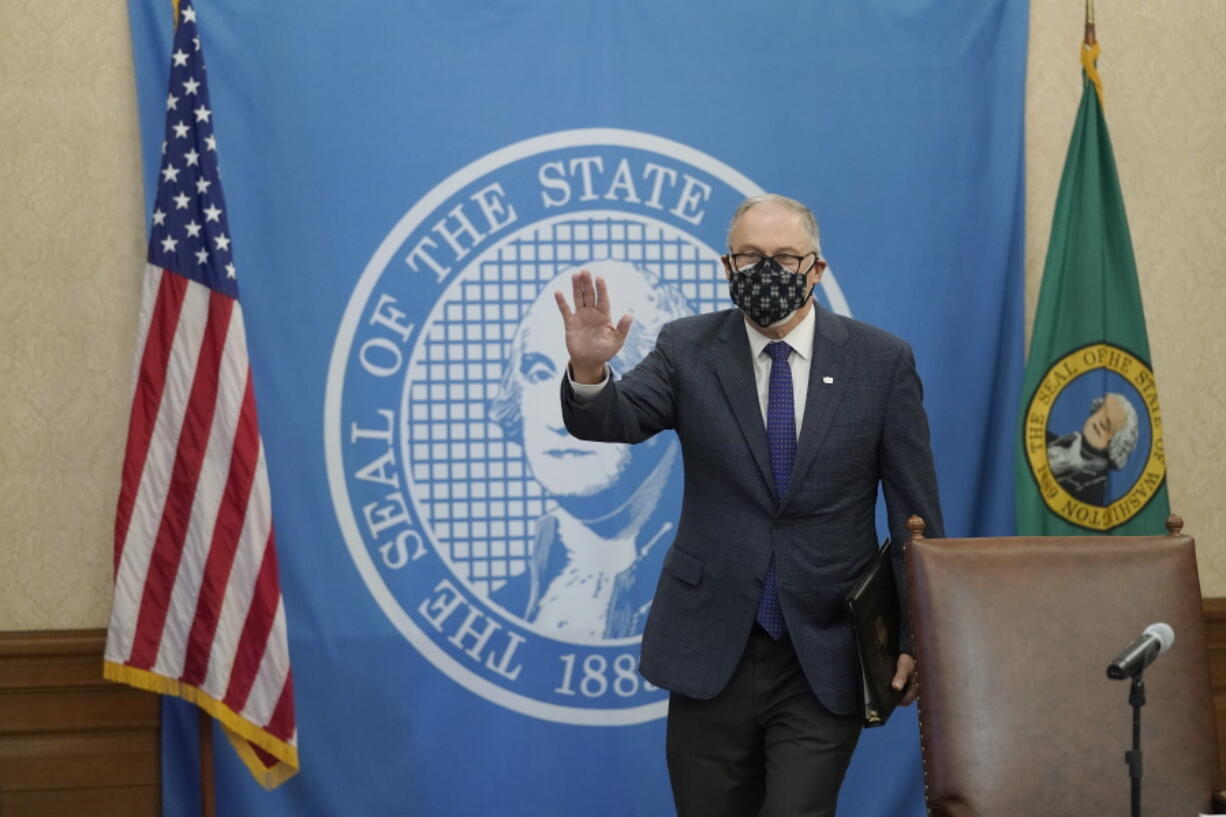 Washington Gov. Jay Inslee arrives to sign the first bill to be signed into law during the 2021 legislative session, Monday, Feb. 8, 2021, at the Capitol in Olympia, Wash. The measure increases the minimum weekly benefit for unemployed workers during the ongoing coronavirus pandemic and prevents a dramatic increase in unemployment taxes paid by businesses. (AP Photo/Ted S.