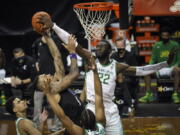 Washington forward Nate Roberts (1) has his shot blocked by Oregon center Franck Kepnang (22) as Oregon guards Will Richardson (0) and LJ Figueroa (12) watch the play during the first half of an NCAA college basketball game Saturday, Feb. 6, 2021, in Eugene, Ore.