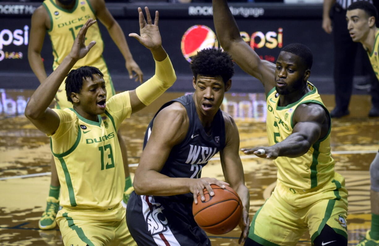 Oregon forwards Chandler Lawson (13) and Eugene Omoruyi (2) pressure Washington State center Dishon Jackson (21) during the first half of an NCAA college basketball game Thursday, Feb. 4, 2021, in Eugene, Ore.