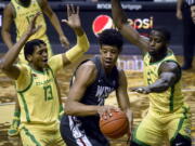 Oregon forwards Chandler Lawson (13) and Eugene Omoruyi (2) pressure Washington State center Dishon Jackson (21) during the first half of an NCAA college basketball game Thursday, Feb. 4, 2021, in Eugene, Ore.